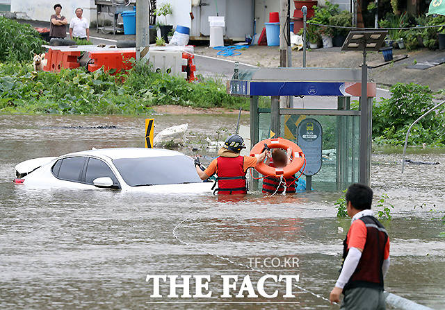 6일 경기 파주시 파평면 율곡리 일대 도로가 폭우로 인한 임진강 수위 상승으로 물에 잠긴 가운데 주행 중이던 차량이 침수되어 119 구조대원이 운전자를 구조하고 있다. /파주=뉴시스