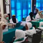 Petugas layanan kesehatan haji melayani lansia kloter 1, Selasa, 28 Mei. Foto: aceh.kemenag.go.id