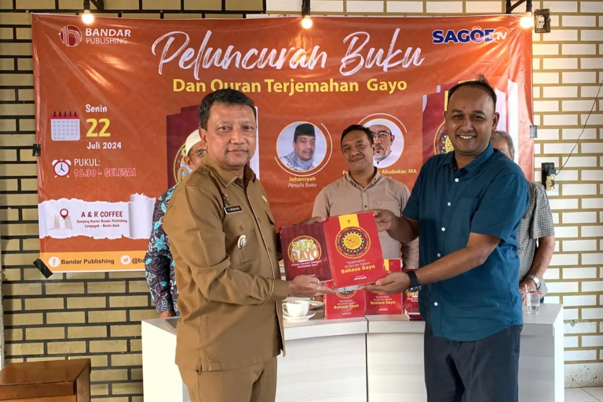 Direktur Bandar Publishing Mukhlisuddin Ilyas menyerahkan buku Terjemahan Al-Qur'an bahasa Gayo kepada Penjabat Bupati Aceh Tengah Teuku Mirzuan. Foto for Line1.News