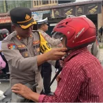 Kapolres Aceh Utara AKBP Nanang Indra Bakti membagikan helm Standar Nasional Indonesia (SNI) gratis kepada pengendara roda dua dan penumpang anak yang tidak memakai helm di kawasan Pos Lantas Kota Lhoksukon, Rabu, 24 Juli 2024. Foto: Humas Polres Aceh Utara
