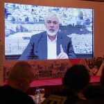 Ismail Haniyeh, berbicara dalam pesan rekaman yang ditayangkan di layar selama acara pers untuk Lembaga Internasional Al Quds di Beirut, Lebanon, pada 28 Februari 2024. Foto: Mohamed Azakir/Reuters