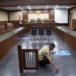 Petugas memeriksa kerusakan ruang sidang pasca vonis SYL di Pengadilan Negeri Jakarta Pusat, Kamis (11/7/2024). Kerusakan pada pagar ruang sidang itu dikarenakan banyaknya massa pendukung SYL saat sidang. Foto: Detik.com/Pradita Utama