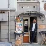 Umit Nar — pemilik toko buku Hermes Sahaf di depan kedainya yang menjual buku-buku bekas dan antik di kota Konak, İzmir, Turki. Foto: AFP