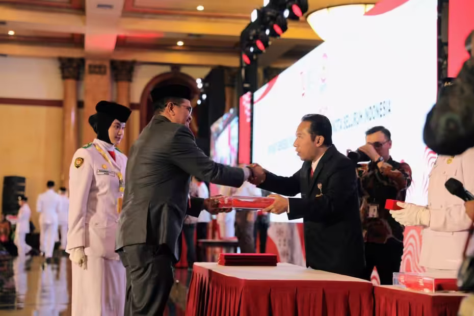 Pj Wali Kota Lhokseumawe A Hanan didampingi Purna Paskibraka Nasional 2023, Raihanah Az-zahra menerima duplikat bendera pusaka dari Sekretaris Utama BPIP di Balai Samudera, Kelapa Gading, Jakarta Utara, Selasa, 6 Agustus 2024. Foto: Istimewa