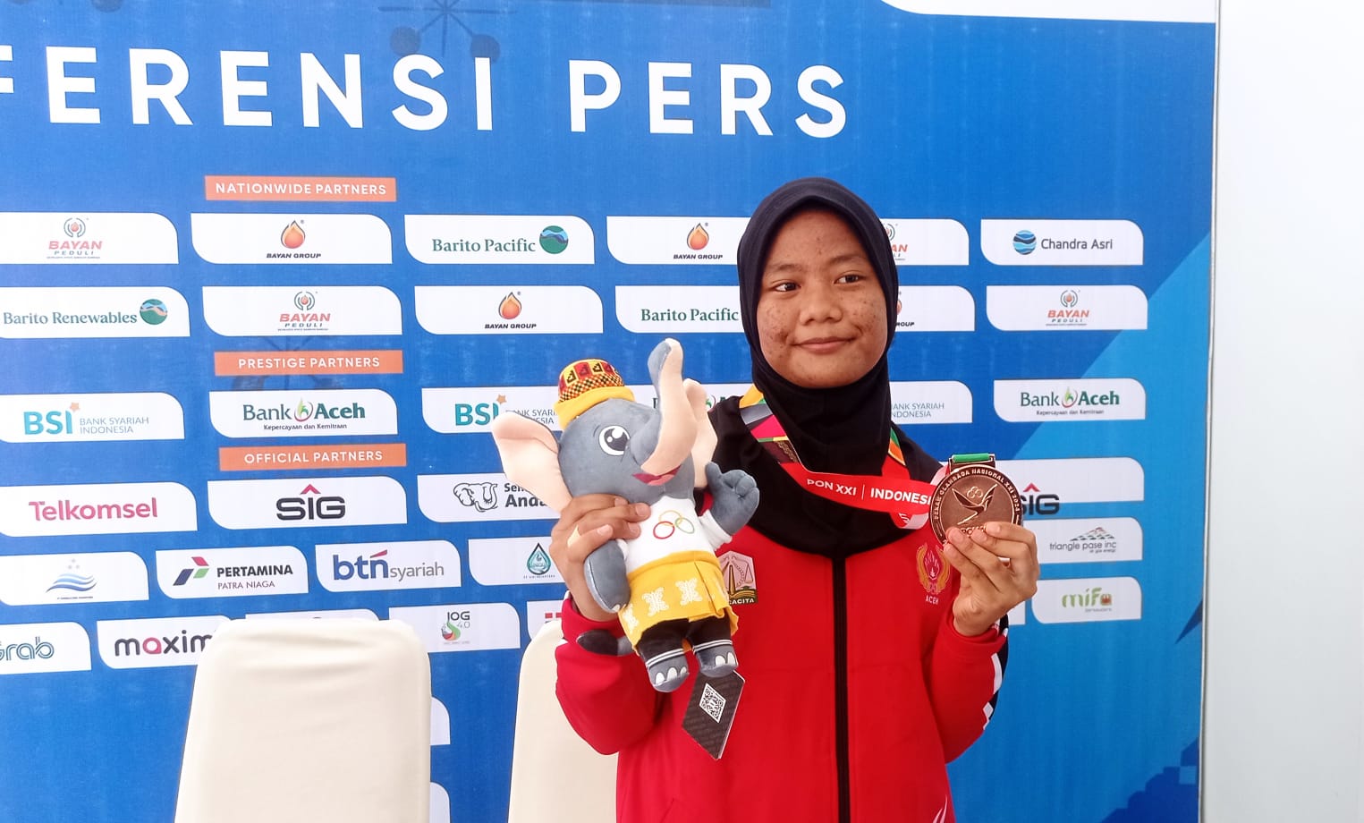 Radhwah Raihanah usai menerima medali perunggu angkat berat nomor 52 kilogram putri. Foto: MC PON ACEH/Fitri Juliana