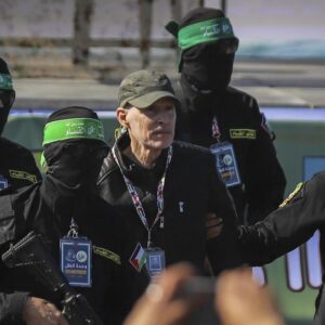 Anggota Hamas bersama seorang sandera Israel