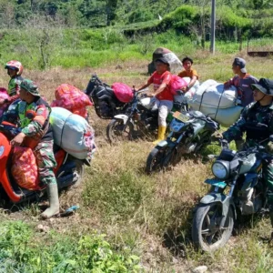 Para anggota TNI mengantar bantuan dengan sepeda motor