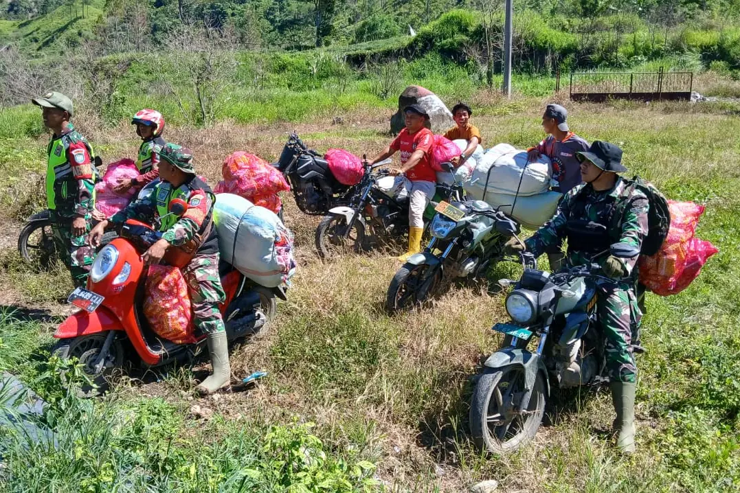 Para anggota TNI mengantar bantuan dengan sepeda motor