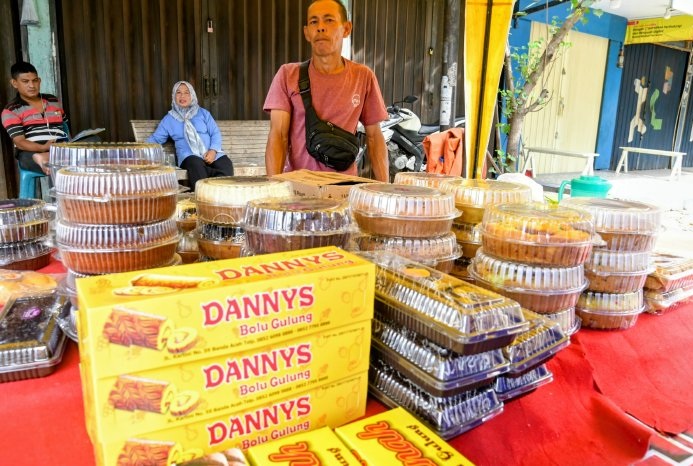 Hasan pedagang kue bolu melayani pembeli di Pasar Lambaro Aceh Besar saat Lebaran 2026.