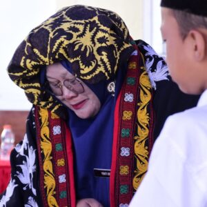 Kepala Sekolah SDN 9 Lut Tawar Yenti Dewi mengenakan pakaian adat Kerawang Gayo tampak haru dalam prosesi Bemunge di Aceh Tengah.