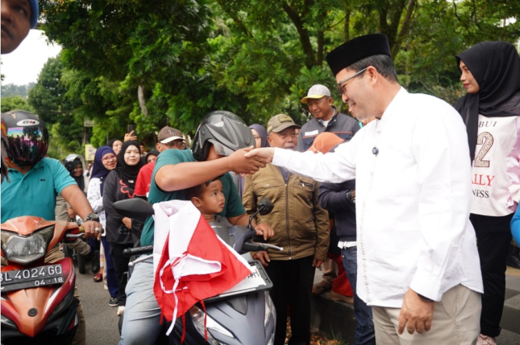 Bupati Haili Yoga bagikan bendera kepada pengendara