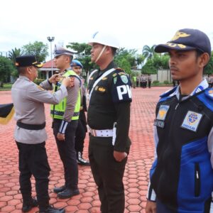 Kapolres Aceh Utara AKBP Trie Aprianto menyematkan pita operasi kepada perwakilan personel TNI, Polri, dan Dishub dalam Apel Operasi Patuh Seulawah 2026.