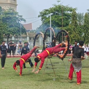 Dua orang santri berseragam merah khas Tapak Suci melakukan atraksi menegangkan melompati lingkaran yang membara oleh api di tengah Lapangan Hiraq Lhokseumawe