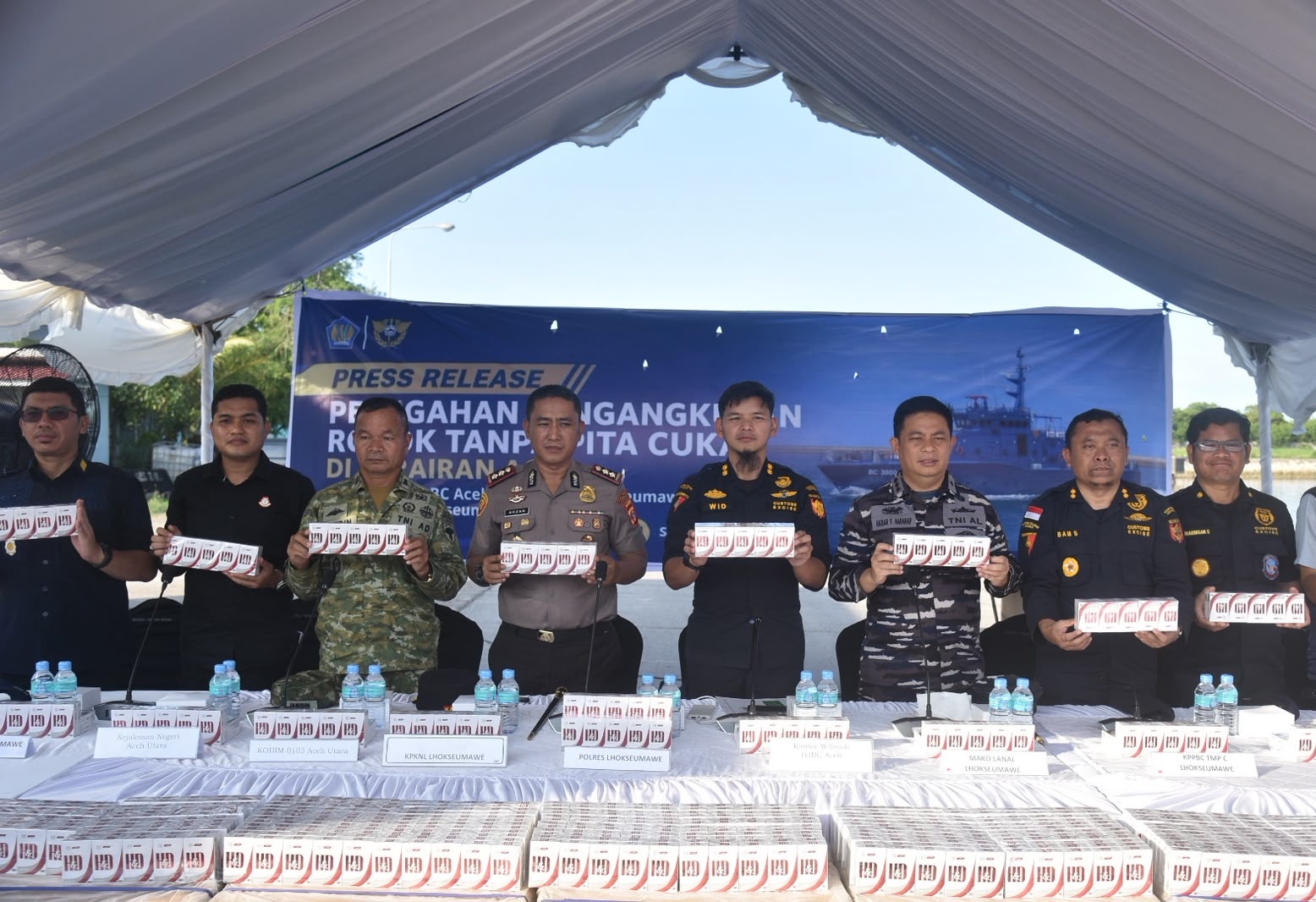 Jajaran pejabat Bea Cukai Aceh, Bea Cukai Lhokseumawe, bersama unsur TNI AL, Polri, dan Kejaksaan berdiri sejajar memegang sampel slop rokok ilegal merek HD dalam konferensi pers penindakan rokok tanpa pita cukai.