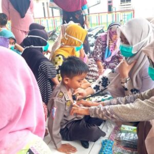 Dokter Raisatul Gebrina memeriksa dada anak kecil dengan stetoskop saat pengobatan gratis di Lhok Puuk Seunuddon
