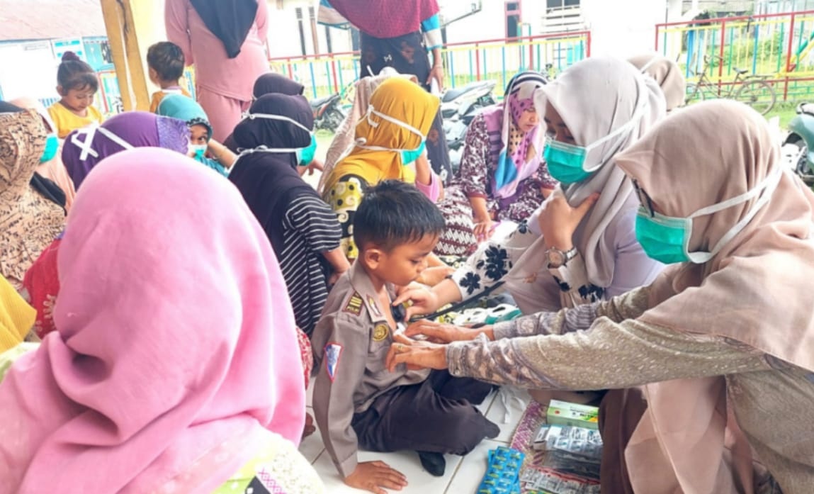 Dokter Raisatul Gebrina memeriksa dada anak kecil dengan stetoskop saat pengobatan gratis di Lhok Puuk Seunuddon