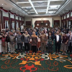 Gubernur Jawa Timur bersama Ketua Umum AMSI dan belasan perwakilan pimpinan media siber berfoto bersama sambil mengepalkan tangan di dalam aula Gedung Negara Grahadi.