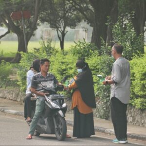 Petugas Dinas Kesehatan Kota Sabang membagikan masker medis kepada pengendara motor di pinggir jalan raya saat kabut asap