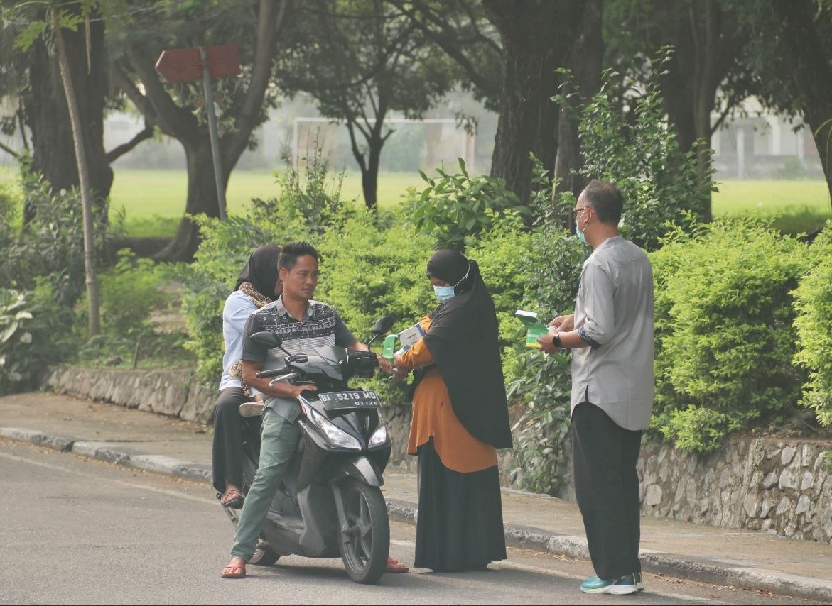 Petugas Dinas Kesehatan Kota Sabang membagikan masker medis kepada pengendara motor di pinggir jalan raya saat kabut asap