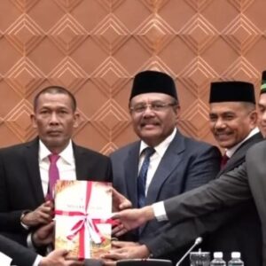 Pj Sekda Aceh Taufik didampingi para wakil ketua menyerahkan map dokumen Nota Keuangan APBA 2027 kepada Ketua DPRA Zulfadli Abang Samalanga.