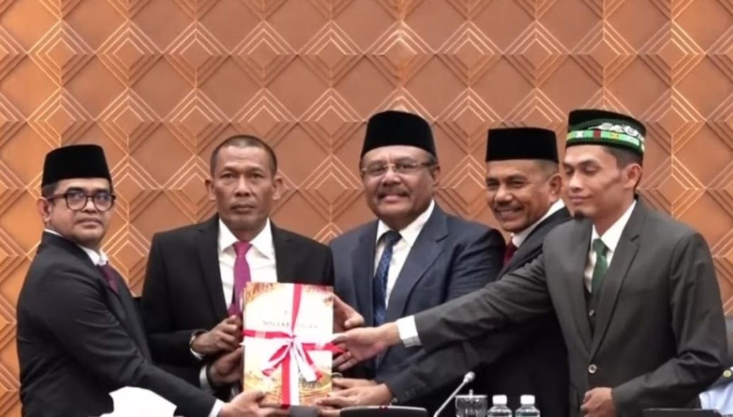 Pj Sekda Aceh Taufik didampingi para wakil ketua menyerahkan map dokumen Nota Keuangan APBA 2027 kepada Ketua DPRA Zulfadli Abang Samalanga.