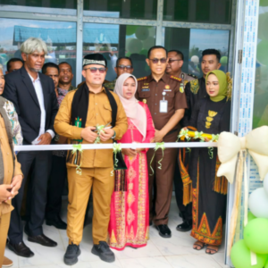 Bupati Aceh Utara Ismail A. Jalil memakai baju cokelat memotong pita peresmian produk air minum kemasan Ie Loen Perumda Tirta Pase didampingi direksi