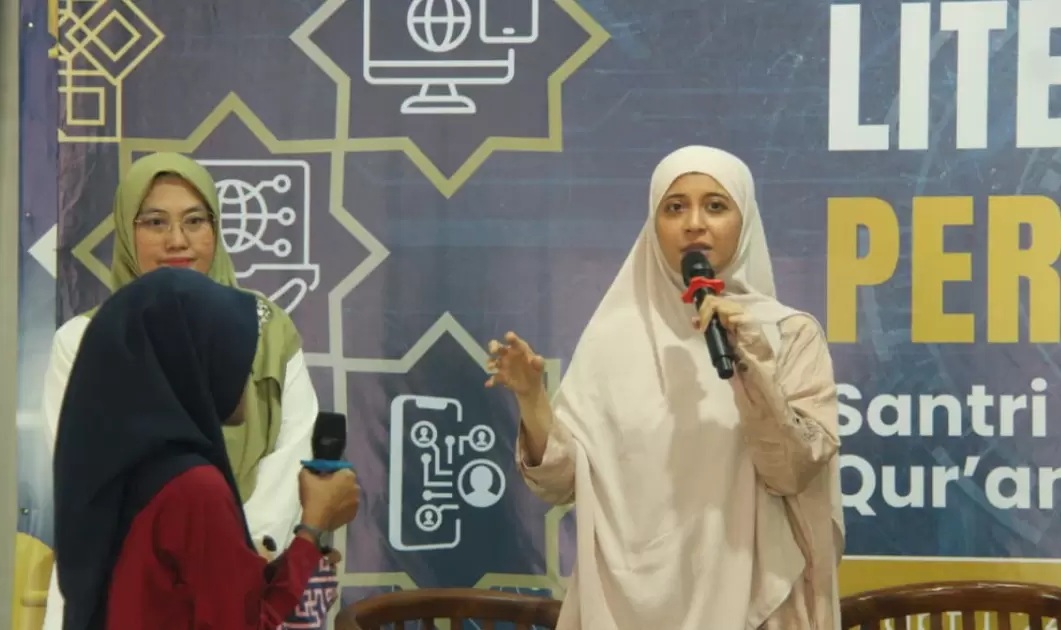 Kepala Pusat Pengembangan Literasi Digital Komdigi Rizki Ameliah mengenakan jilbab krem krem sedang berbicara menggunakan mikrofon di acara literasi digital KPRK MUI di Depok