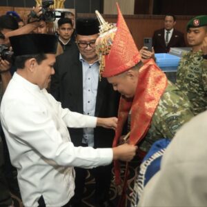Wakil Gubernur Aceh Fadhlullah memakaikan kupiah meukeutop dan menyelimuti kain tradisional Aceh kepada Pangdam IM yang baru Brigjen TNI Mahesa Fitriadi di Bandara SIM