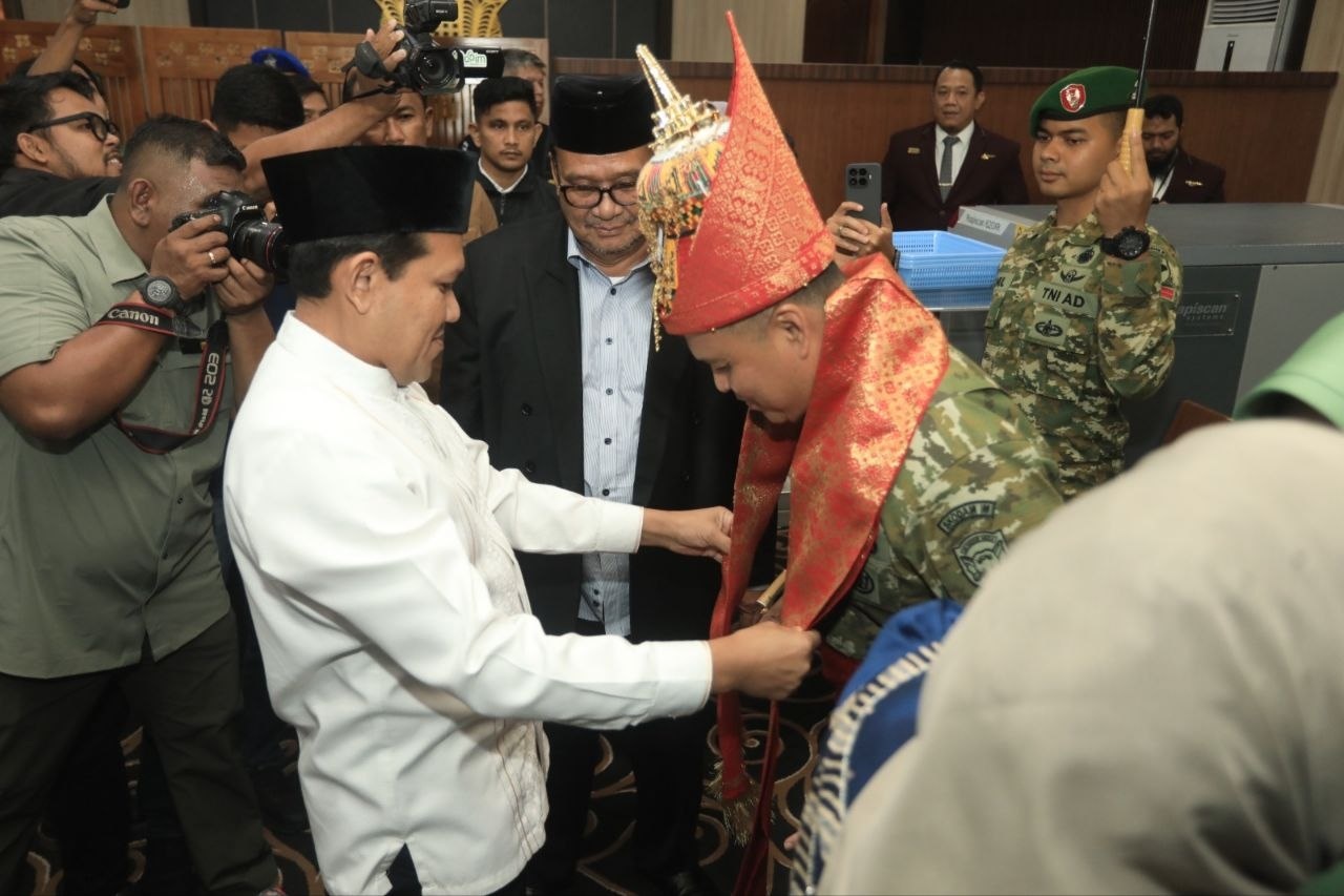 Wakil Gubernur Aceh Fadhlullah memakaikan kupiah meukeutop dan menyelimuti kain tradisional Aceh kepada Pangdam IM yang baru Brigjen TNI Mahesa Fitriadi di Bandara SIM