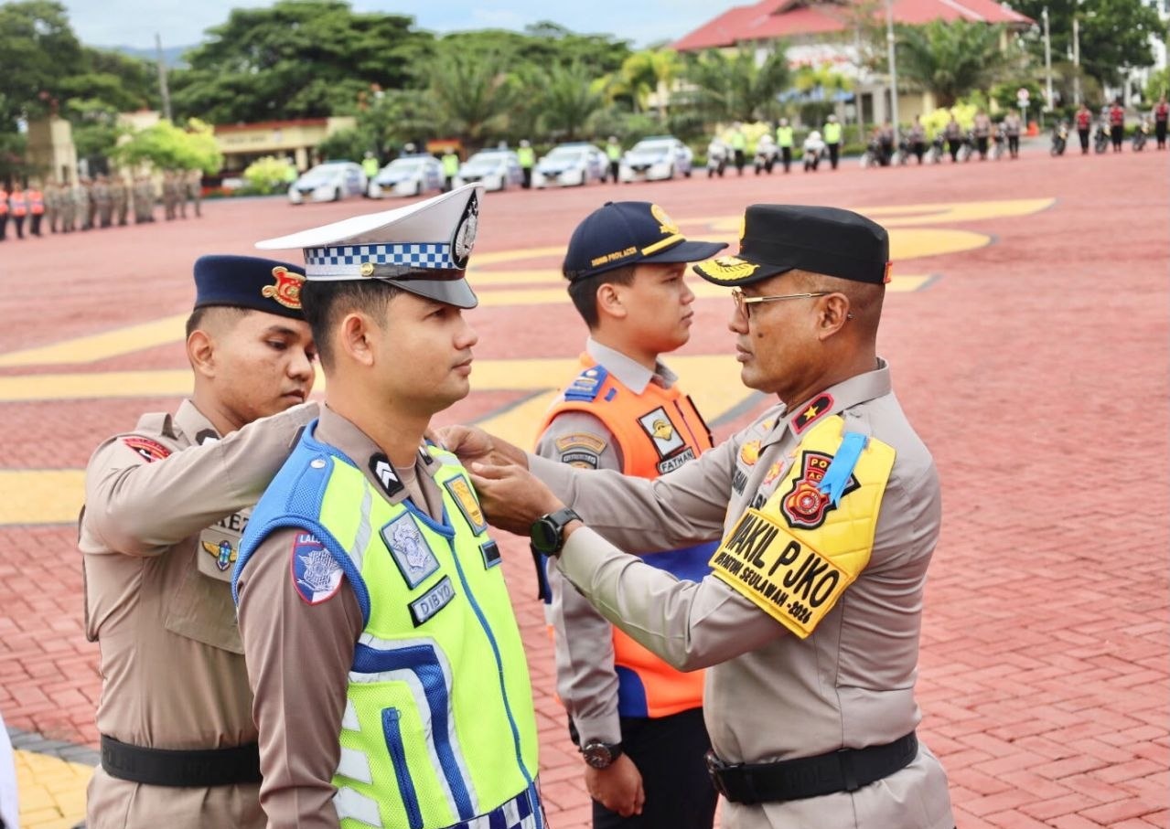 Wakapolda Aceh Brigjen Pol Latif Usman mengenakan ban lengan Wakil PJKO menyematkan pita operasi kepada personel polisi lalu lintas.