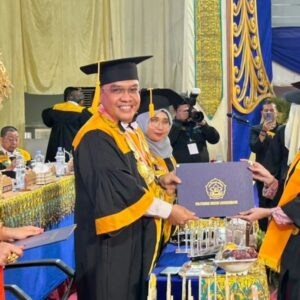 Direktur PNL Rizal Syahyadi menyerahkan dokumen ijazah secara simbolis kepada salah satu wisudawati berprestasi di atas panggung Auditorium PNL Lhokseumawe.